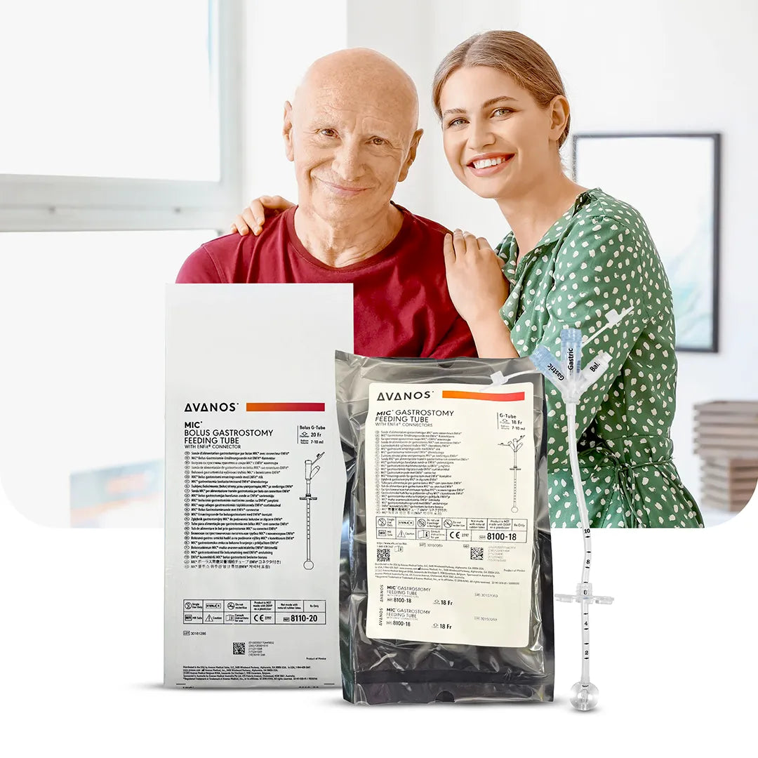 Smiling caregiver with elderly man beside Avanos MIC and MIC Bolus Gastrostomy Feeding Tubes, showing ENFit connectors and packaging, available at Medisa.