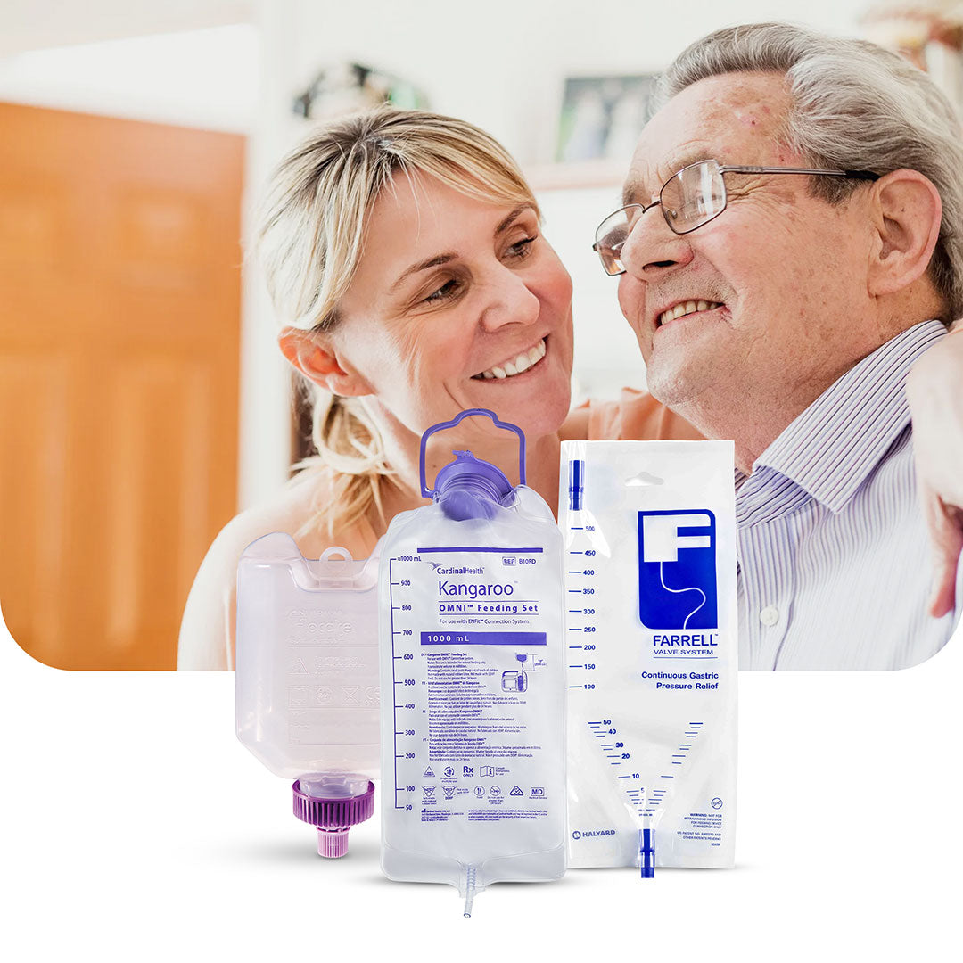 Smiling caregiver assisting an elderly man with enteral feeding containers, including Kangaroo Omni Feeding Set, Farrell Valve System, and other sterile feeding solutions.