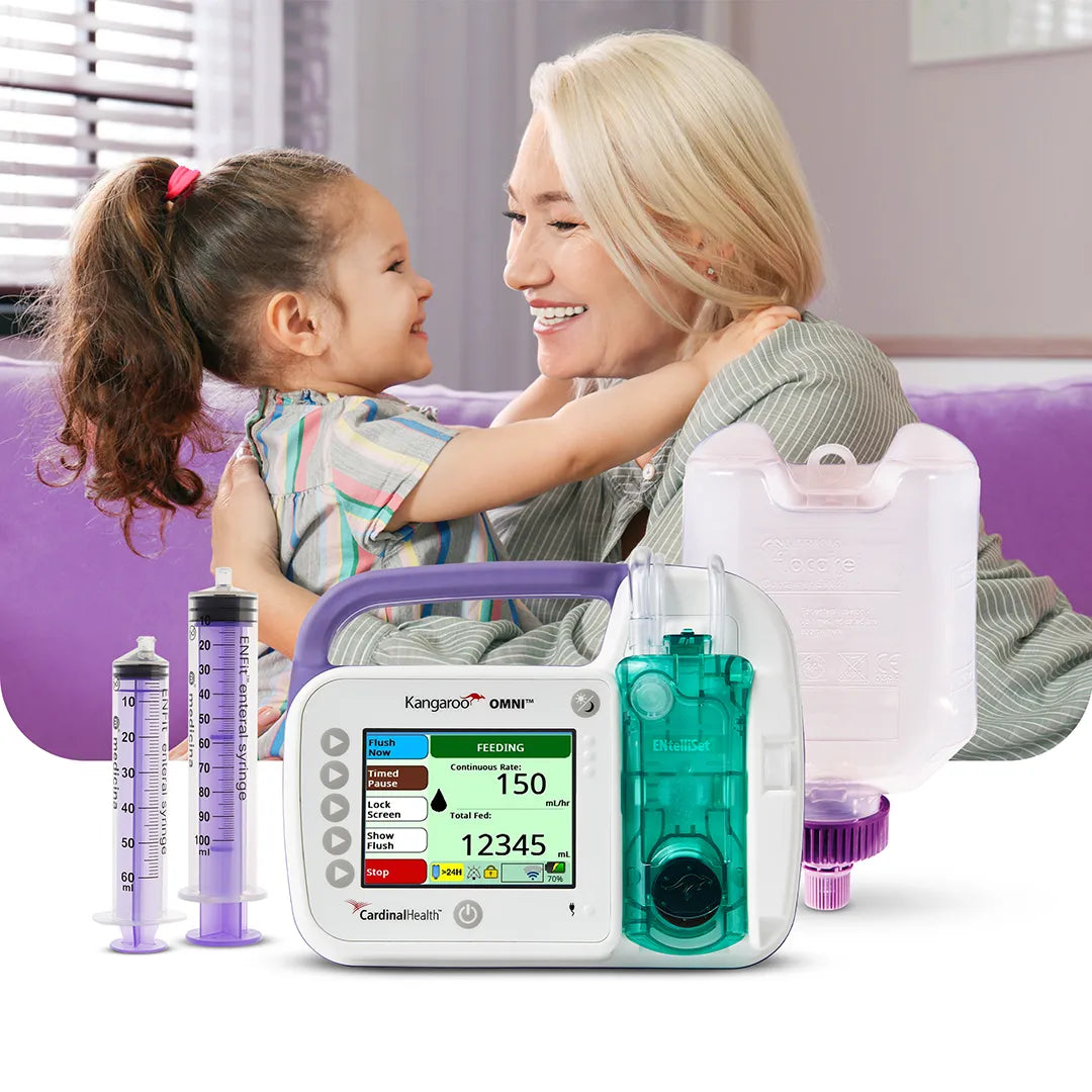 Woman hugging child with Kangaroo™ OMNI™ feeding pump, ENFit syringes, and nutrition container in foreground.